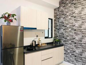 uma cozinha com um frigorífico e uma parede de pedra em PARC 3 in Cheras, #Sunway Velocity #IKEA #TRX em Kuala Lumpur