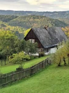 Koberovy的住宿－Stylový vesnický apartmán v soukromí M. Skála Český Ráj，田野上带黑色屋顶的谷仓
