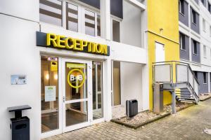 facciata di un edificio con un cartello giallo di evacuazione di B&B HOTEL Köln-Frechen a Frechen