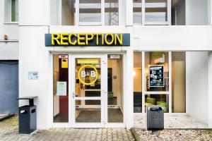 un edificio blanco con un cartel que dice recepción en B&B HOTEL Köln-Frechen, en Frechen