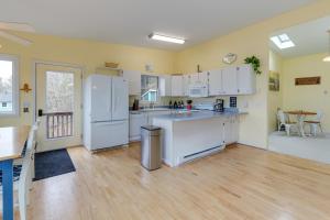 una cucina con elettrodomestici bianchi e pavimento in legno di Family Friendly Mears Cottage - Walk to the Beach! a Mears