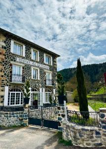 a stone house with a gate in front of it at HL Hotel de la Loire in Goudet