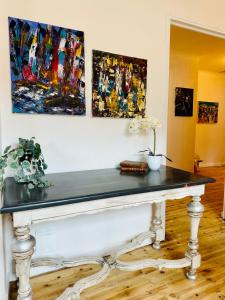 a table in a room with paintings on the wall at HL Hotel de la Loire in Goudet