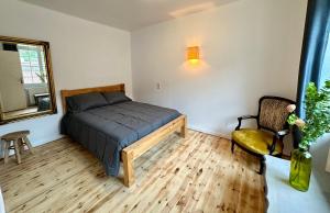 a bedroom with a bed and a chair and a window at HL Hotel de la Loire in Goudet