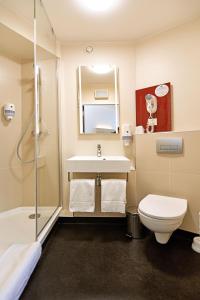 een badkamer met een wastafel, een toilet en een douche bij B&B Hotel Łódź Centrum in Łódź