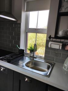 a kitchen with a sink and a window at Apartments at Ballinsheen House & Gardens in Lisdoonvarna