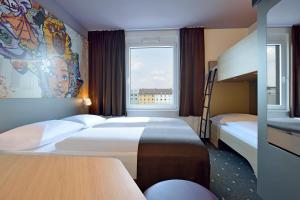 B&B Hotel Köln-Ehrenfeld في كولونيا: غرفة فندقية بسريرين ونافذة