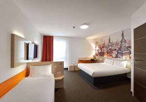 ルブリンにあるB&B Hotel Lublin Centrumのベッド2台とテレビが備わるホテルルームです。