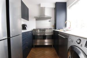 a kitchen with a stainless steel stove and a dishwasher at Hughes contemporary home in Barnstaple by StayStay com in Barnstaple