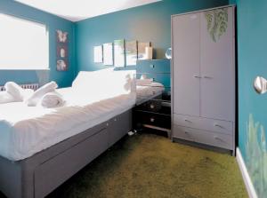 een slaapkamer met een groot bed en een blauwe muur bij Hughes contemporary home in Barnstaple by StayStay com in Barnstaple