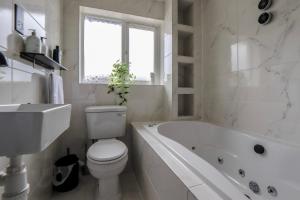 een badkamer met een toilet, een bad en een wastafel bij Hughes contemporary home in Barnstaple by StayStay com in Barnstaple