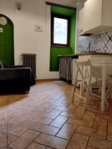 a kitchen with green walls and a table and chairs at Casa della chiocciola in Castel del Piano