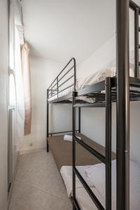 a room with three bunk beds in a room at Appartement 4 pers à 50m de la plage, avec piscine in Roquebrune-Cap-Martin