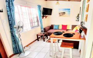 sala de estar con mesa y sofá en Cape Cozy Cottages en Ciudad del Cabo