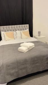Cama con almohadas blancas y manta gris en Large Room 2, en Bristol