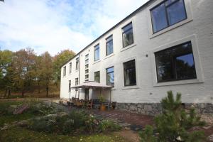 - un grand bâtiment blanc avec une terrasse en face dans l'établissement VEPA, à Vepriai