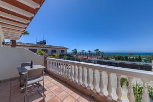 a balcony of a house with a table and chairs at Dulce Nombre Hotel - Apartamentos in Tarifa