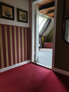 uma porta aberta para um quarto com tapete vermelho em Haus "Asgard" em Brinjahe