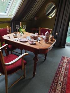 - une table en bois avec des assiettes et des verres à vin dans l'établissement Haus "Asgard", à Brinjahe