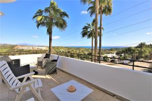 einen Balkon mit Blick auf das Meer und die Palmen in der Unterkunft Apartment GENOA in Estepona