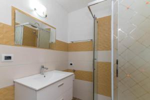 uma casa de banho com um lavatório e um chuveiro em Monolocale grande em La Maddalena