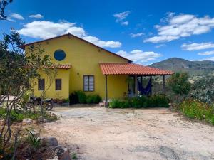 a yellow house with a red roof at Casa Aya in Ibicoara