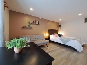 1 dormitorio con cama, sofá y mesa en Habitations Zenith en Sainte-Anne-de-Beaupré