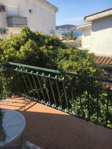 a balcony with a green fence and a table at Apartments Orhideja in Bar