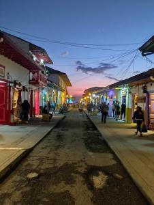 Una calle de la ciudad por la noche con gente caminando por la calle en Hostal Villa del Sol en Salento