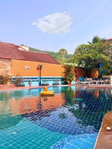 a swimming pool with a yellow float in the water at Baankasemsuk Resort 般咔 深宿 in Patong Beach