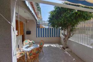 Un patio con una mesa y sillas y un árbol. en Bungalow Catral 20 en Santa Pola, en Santa Pola