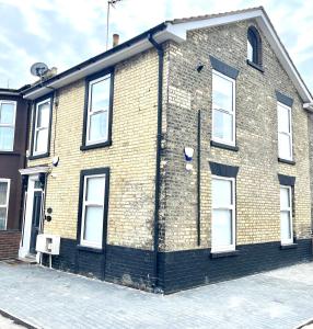 a brick building with white windows on a street at Corner Stone House - Apartment 1 in Great Yarmouth