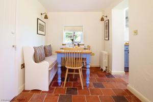 cocina con mesa azul y silla blanca en New Lane Cottage en Worstead