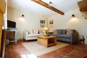a living room with a couch and a table at New Lane Cottage in Worstead