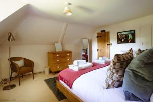 Worstead的住宿－New Lane Cottage，一间卧室配有一张大床和一把椅子