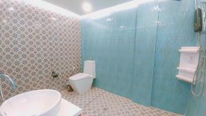 e bagno con servizi igienici, lavandino e doccia. di มารินอส บีชเฮ้าส์ Marinos Beach house a Si Racha