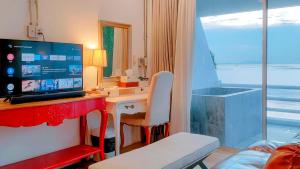 Habitación con escritorio, ordenador y ventana. en มารินอส บีชเฮ้าส์ Marinos Beach house, en Si Racha