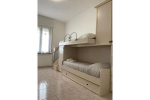 a small bedroom with a bed and a cabinet at Pierluigi's House in Cagliari