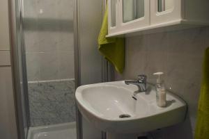 La salle de bains est pourvue d'un lavabo et d'une douche. dans l'établissement Grupo Gontad Apartamento iker Ponteceso, à La Corogne