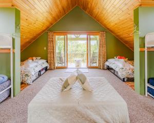 Zimmer mit 2 Betten und einem großen Fenster in der Unterkunft Dragonwood Retreat 