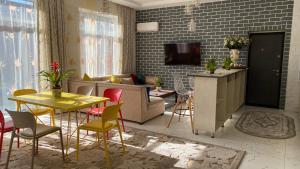 塔什坎的住宿－Duplex80，客厅配有黄色的桌子和椅子