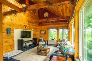 ein Wohnzimmer mit Holzwänden und einem großen Fenster in der Unterkunft Dragonwood Retreat 