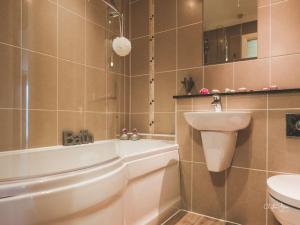 a bathroom with a tub and a sink and a toilet at Honeybee Cottage 15P in North Petherton