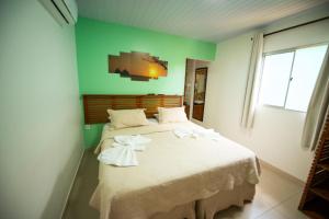 una camera da letto con un letto grande con asciugamani sopra di Pousada Flôr do Atlântico a Fernando de Noronha