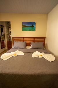 een slaapkamer met 2 bedden en handdoeken bij Pousada Flôr do Atlântico in Fernando de Noronha