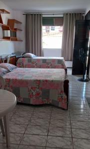 a bedroom with two beds and a table at Casa Verde Albuquerque in Fortaleza