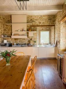 uma grande cozinha com uma mesa de madeira e cadeiras em Palazzo Serre - Natura & Piscina em San Leo