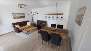 uma sala de estar com uma mesa de jantar e um sofá em Ferienwohnung Claudia mit Terrasse em Nussdorf am Attersee