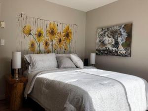 a bedroom with a bed and a painting on the wall at Séjour, Flèche du fjord, vue Saguenay, Mont Valin in Saint-Fulgence