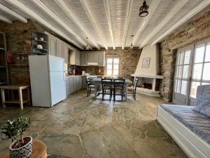 a kitchen with a table and a white refrigerator at The Traditional Stone Villa in Koundouros